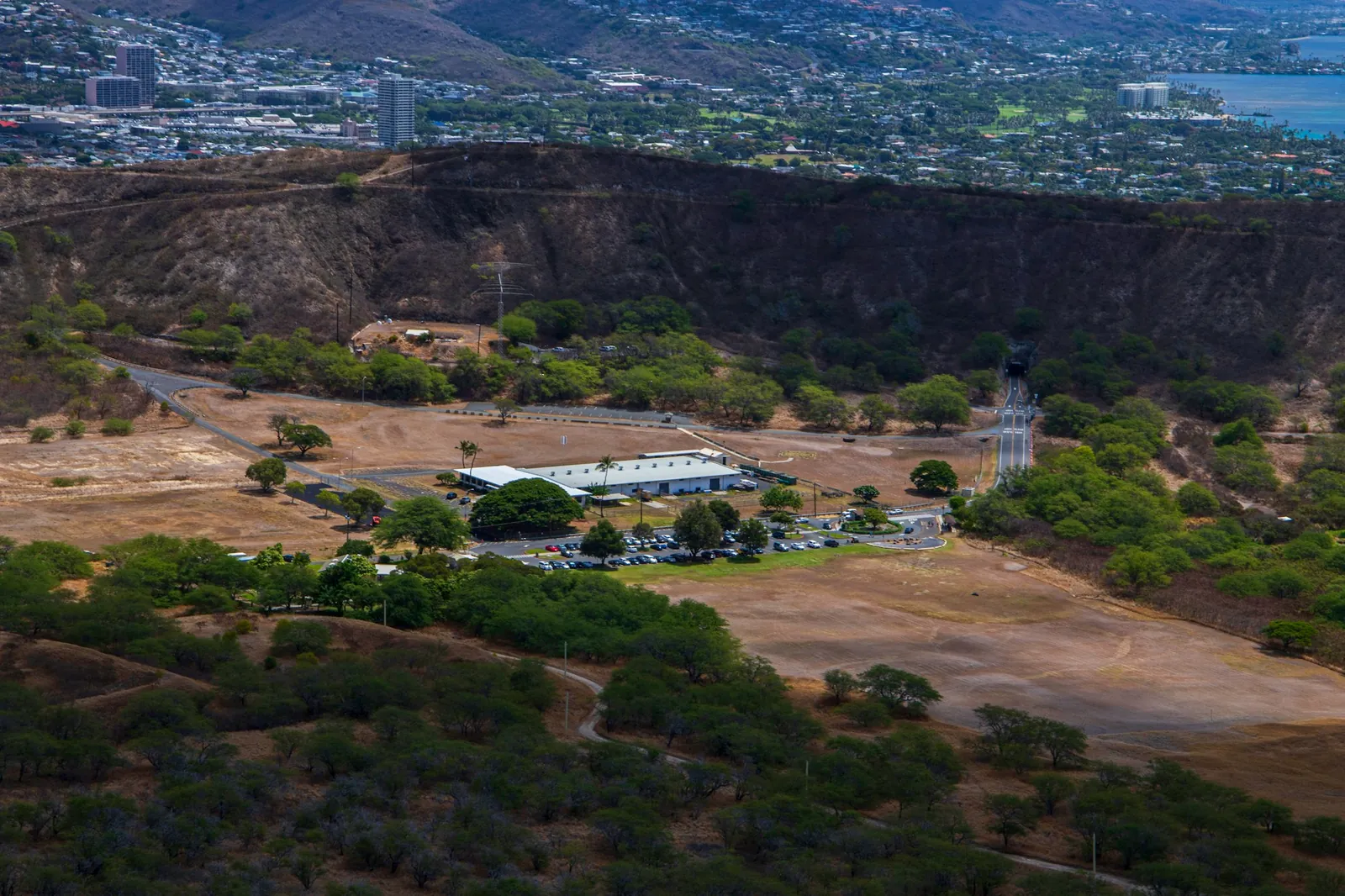 Aerial view of a large building surrounded by trees and open land