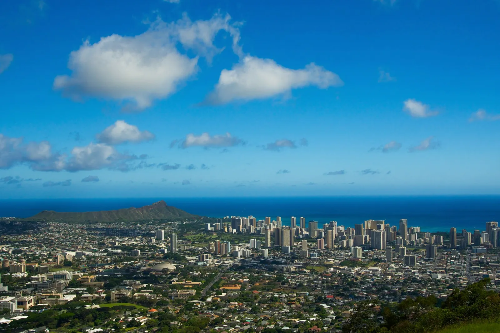 Honolulu city buildings and the coastline under a blue sky