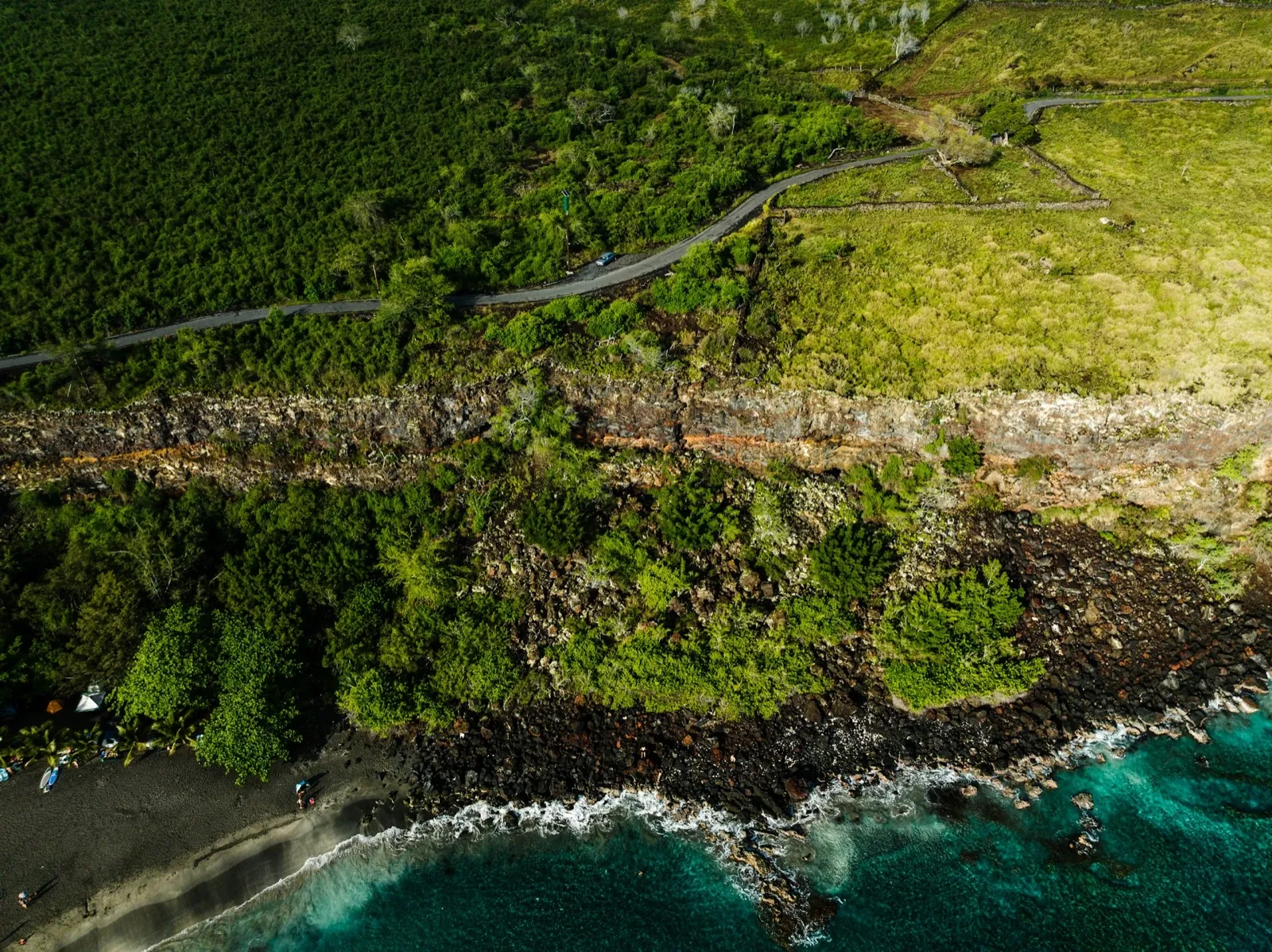 Aerial view of a winding road along steep green hills