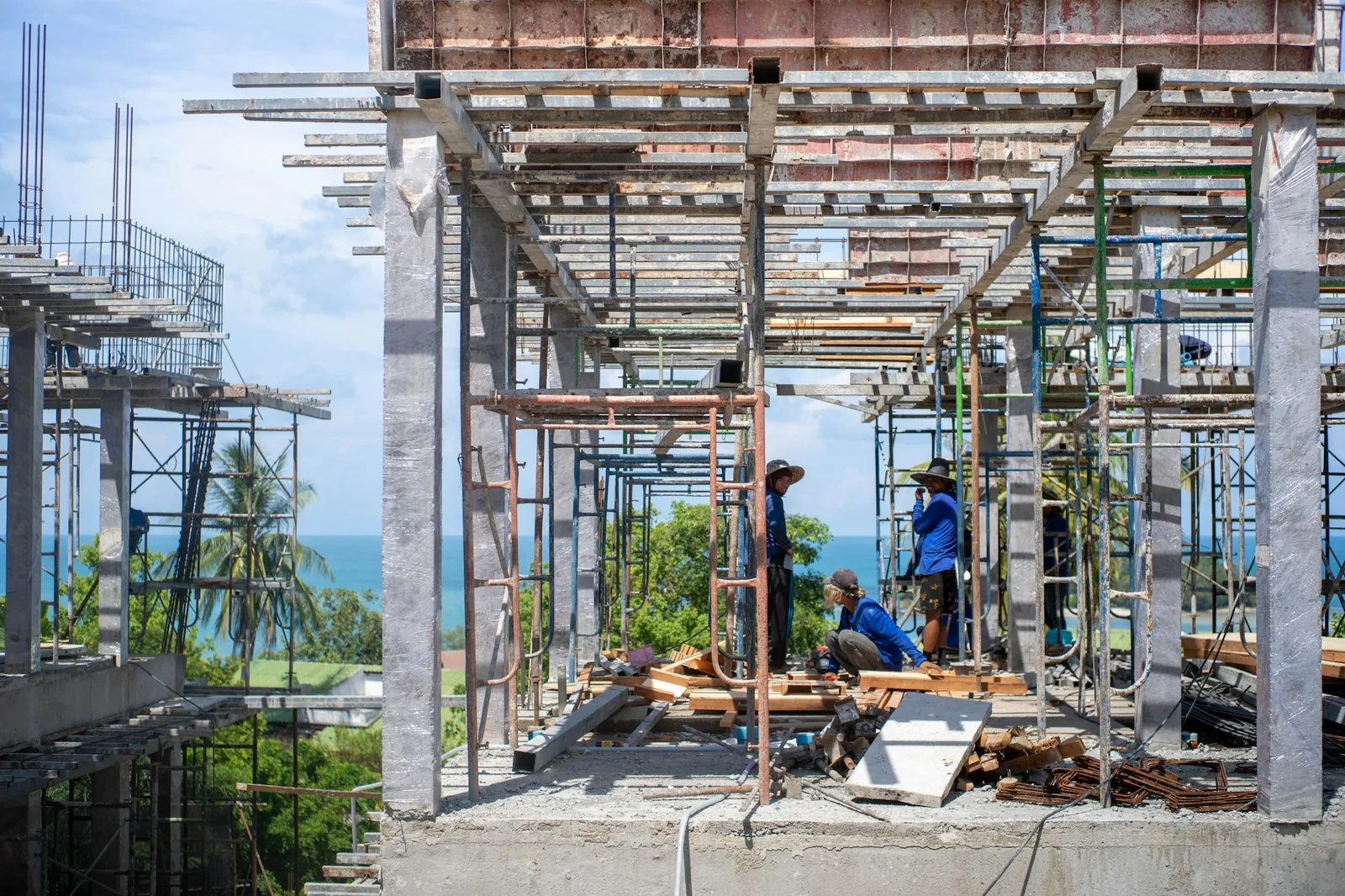 Workers on a building construction site near the ocean