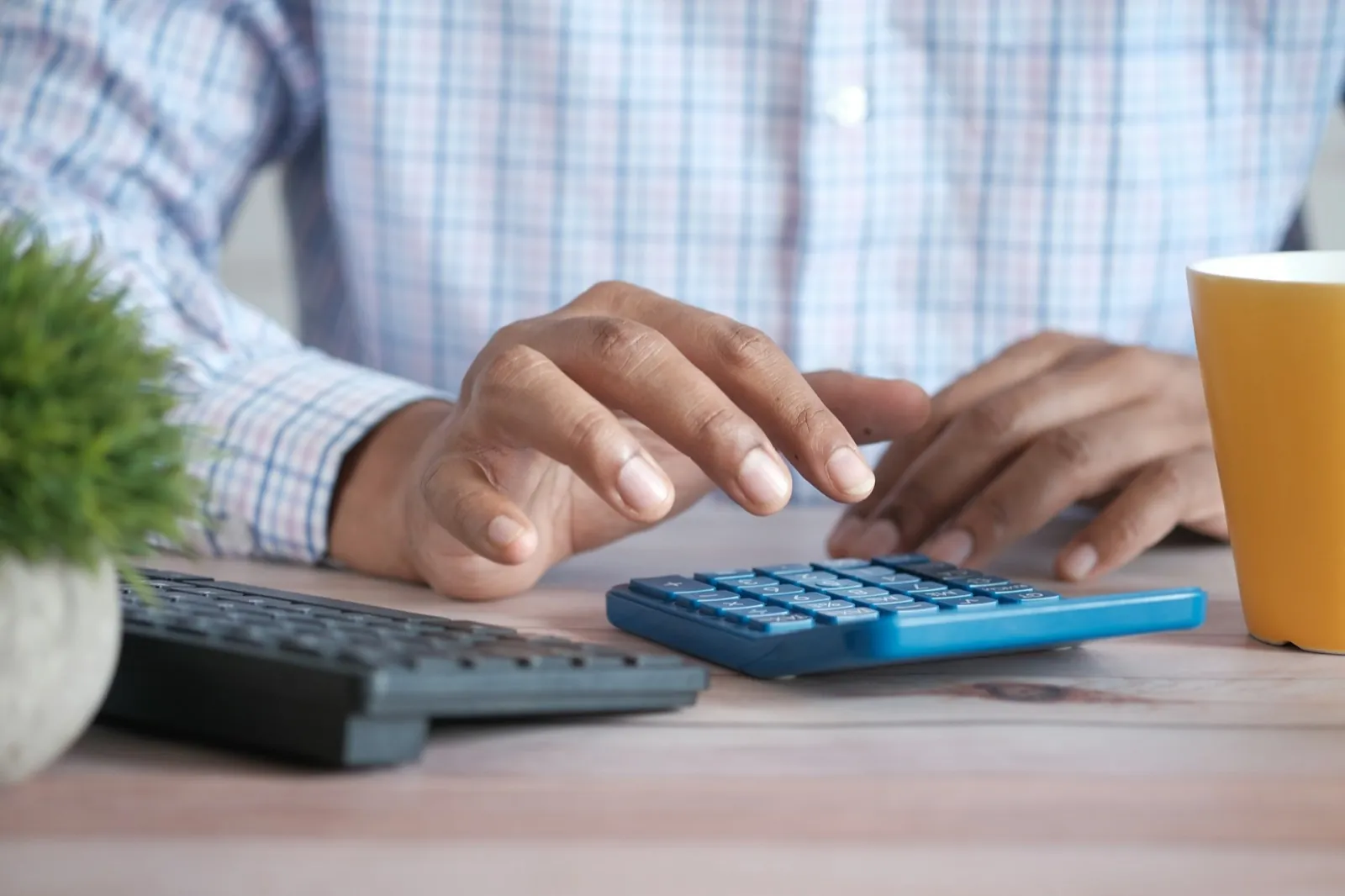 Person using a calculator at a desk with papers