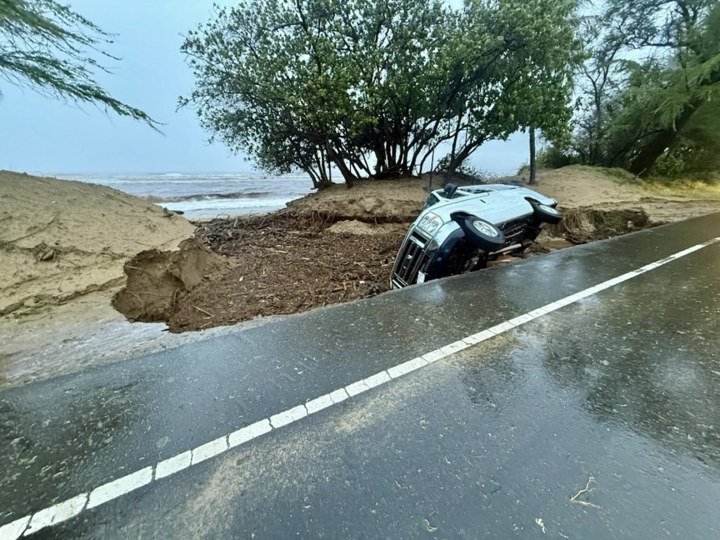 A van sunk into a collapsed section of South Kīhei Road during the March 14, 2026 Kona Low storm on Maui