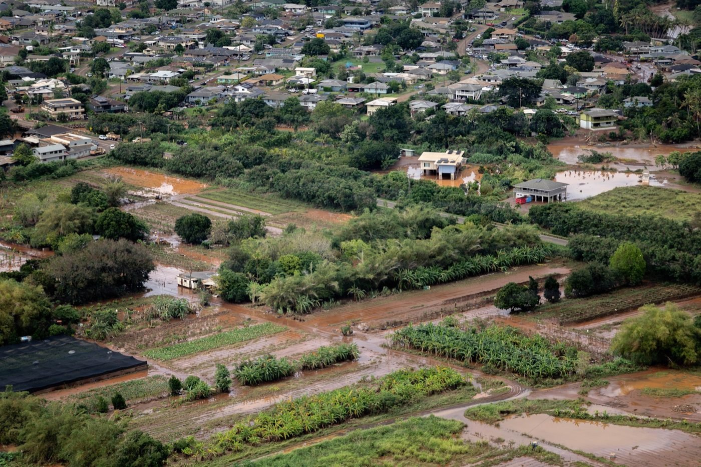 Aerial view from a U.S. Army helicopter of brown floodwater across farms and homes on the North Shore of Oʻahu, March 21, 2026