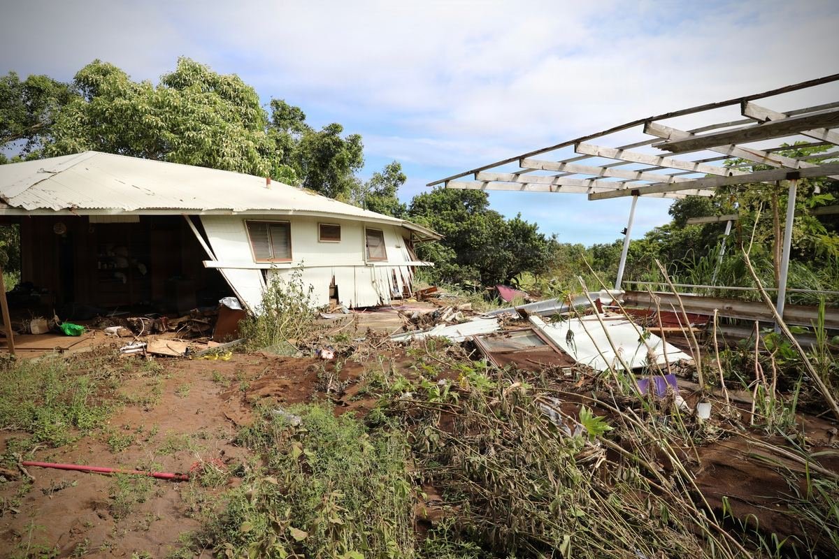 A storm-damaged Hawaii home with a collapsed carport after Hurricane Lala