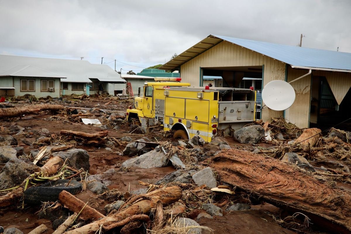 A fire truck buried in mud and debris between damaged buildings after Hurricane Lala on Hawaii Island