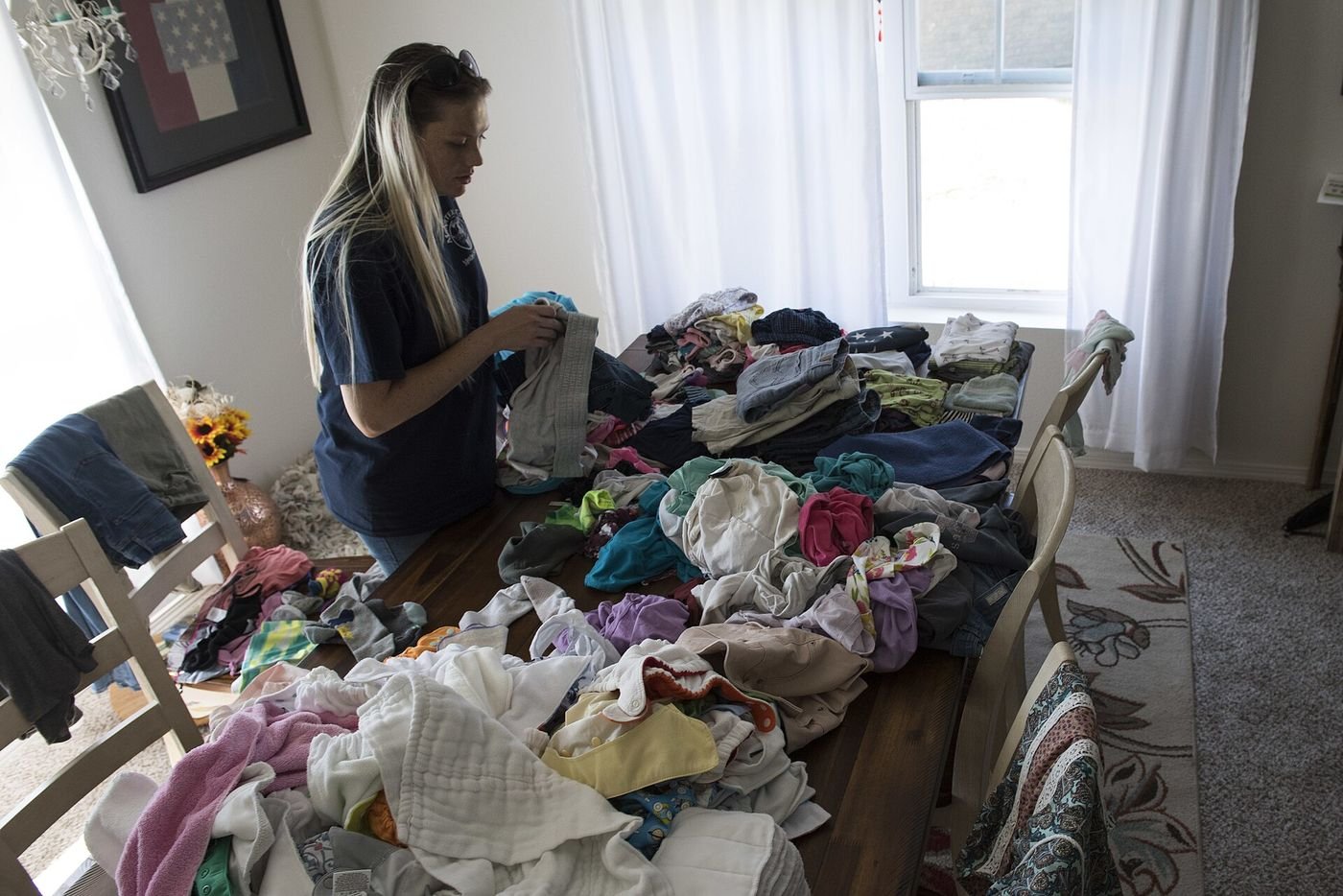 A homeowner sorts through water-damaged clothing and belongings