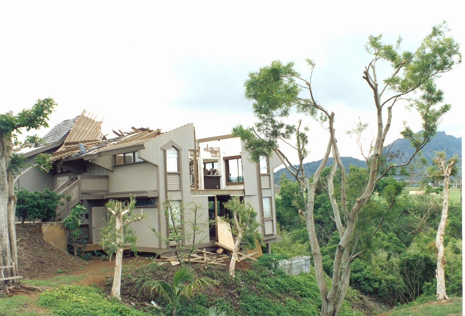 A Kauaʻi home with its roof and upper floor torn open by hurricane winds