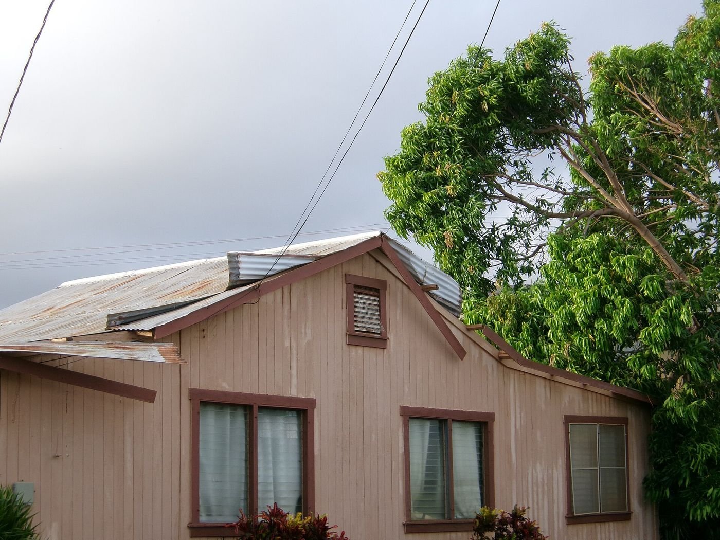 A plantation-style house on Alawai Road in Waimea, Kauaʻi, with wind damage to its roof after Hurricane Lowell, September 2026